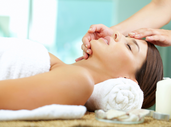 Young woman enjoying facial at spa salon