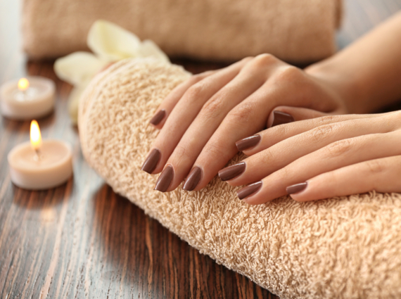 Female hands with brown manicure on towel