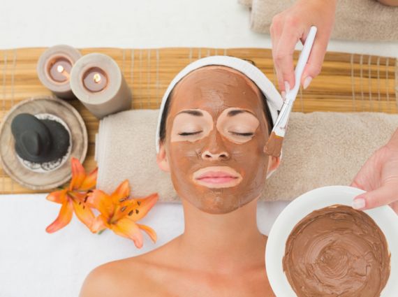 Peaceful brunette getting a mud treatment facial in the health spa