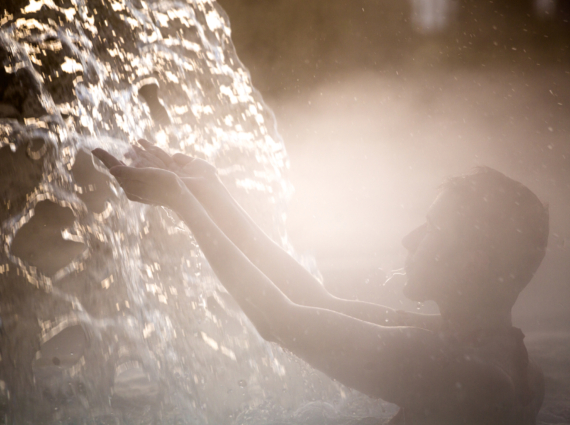 Happy young woman relaxing in thermal pool.